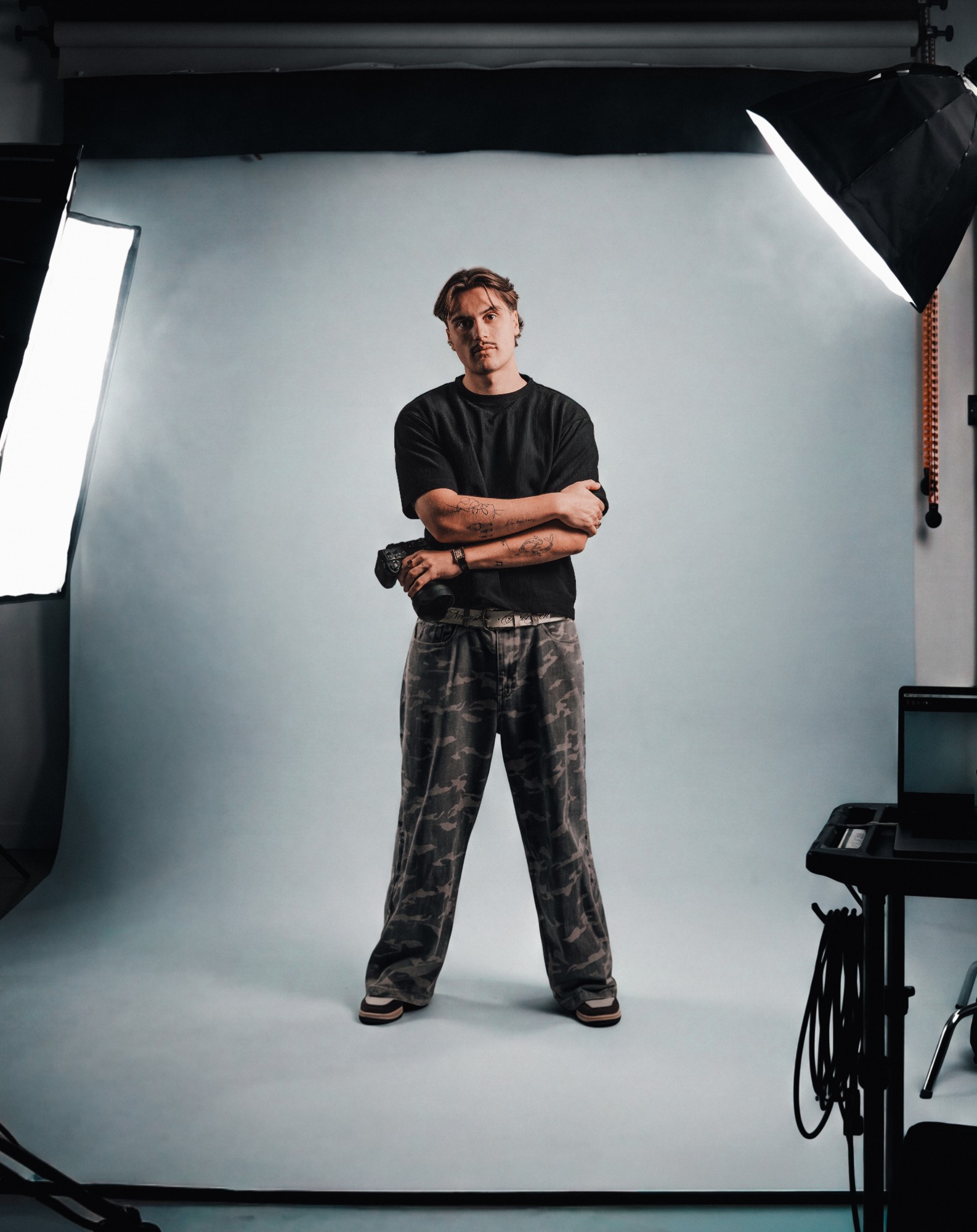 Sem, staand met een camera in de studio